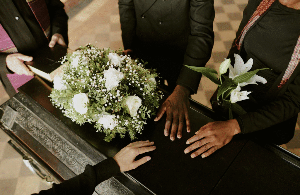 Mourners touching coffin at funeral